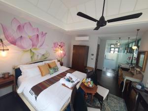 曼谷The Knight House Bangkok的卧室配有一张大床,墙上挂着粉红色的鲜花