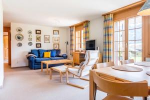 格林德尔瓦尔德Apartment Hori - GRIWA RENT AG的客厅配有蓝色的沙发和桌子