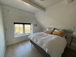洛肯洛肯家庭露营地的白色的卧室设有床和窗户