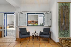 孔波尔塔Comporta Center Villa的带窗户的客房内配有两把椅子和一张桌子