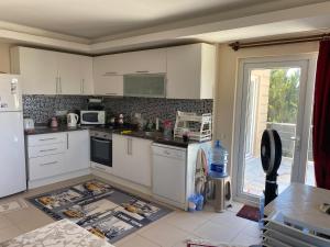 穆拉kayra villa的厨房配有白色橱柜,厨房地毯位于地板上