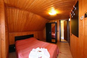 兰卡Casa Teodora Rânca的木制客房内的一间卧室,配有一张床