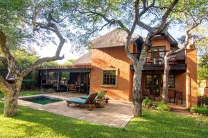 侯斯普瑞特Braai Safaris Lodge的一座带庭院和游泳池的房子