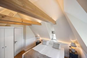 兰图姆Ferienhaus Miarwuefki的卧室设有白色的床和木制天花板。