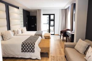 斯瓦科普蒙德Swakopmund Sands的酒店客房,设有两张床和一张沙发