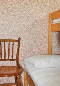 维默比Stuga i vassemåla的一间卧室配有一张床和一张木椅