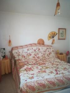 卡拉赛达casa vacanze calasetta的卧室内的一张带花卉棉被的床