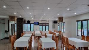 河江Friend Hotel Hà Giang的用餐室配有白色的桌子和木椅