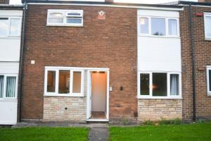 Willenhall2ndHomeStays- Willenhall-A Serene 3 Bed House with a Garden View-Suitable for Contractors and Families-Sleeps 9 - 7 mins to J10 M6 and 21 mins to Birmingham的红砖房子,有白色门