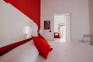 锡拉库扎克雅诺斯住宅酒店的红色和白色的卧室配有白色的床铺和红色枕头