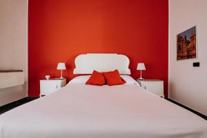 锡拉库扎克雅诺斯住宅酒店的卧室配有白色的床铺和红色的墙壁