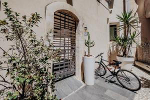 锡拉库扎克雅诺斯住宅酒店的一辆自行车停在一扇种植了植物的门口