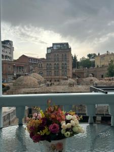 第比利斯Apartment in historical district of Tbilisi的阳台上的花瓶里放着一束鲜花