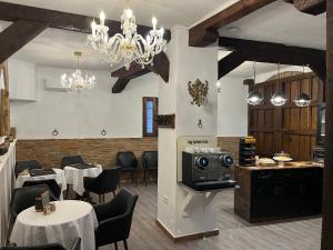 瓜迪克斯HABITACIONES LAS TERMAS的餐厅配有白色的桌椅和吊灯