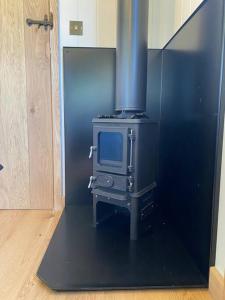 KettonThe Black Swan Shepherd Hut的厨房配有炉灶和电视。