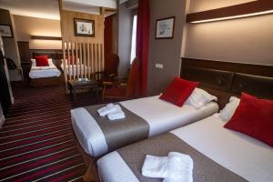 圣马洛吕尼韦尔酒店的酒店客房 - 带两张带红色枕头的床