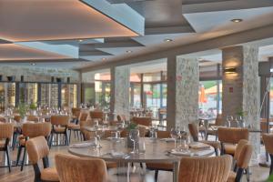 沙穆伊Hôtel du Golf de l'Ailette, The Originals Relais (Qualys-Hotel)的用餐室设有桌椅和窗户。