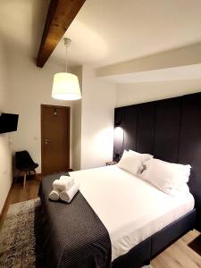 比索达雷加Arriaga Douro House的一间卧室配有一张白色大床和黑色床头板