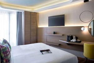 雅典雅典温德姆公寓酒店的配有一张床和一台平面电视的酒店客房