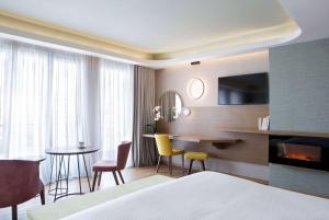 雅典雅典温德姆公寓酒店的酒店客房带一张床、一张桌子和椅子
