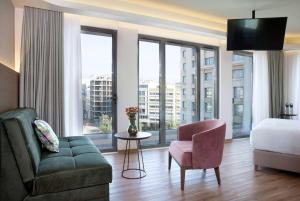 雅典雅典温德姆公寓酒店的酒店客房配有床、沙发和椅子