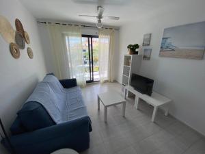 阿尔考斯布里Apartamentos Porta Mediterranea Altamar的客厅配有蓝色的沙发和电视