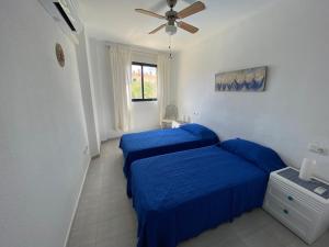 阿尔考斯布里Apartamentos Porta Mediterranea Altamar的一间卧室配有2张蓝色的床和吊扇