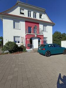 Lahr-DinglingenZimmer "Beere"的停在房子前面的蓝色汽车