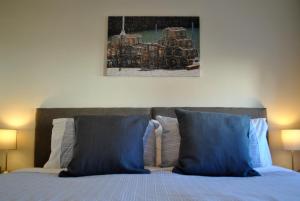 安斯特拉瑟Forth View- stylish upper apartment with sea views的一张带蓝色枕头的床和上面的绘画