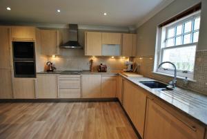 克雷尔Darnley View- spacious countryside retreat的厨房配有木制橱柜、水槽和窗户。