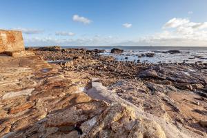 安斯特拉瑟Honeybee Cottage- stunning home on Fife coast的一片岩石海滩,拥有海洋