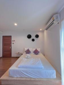 清迈Chiang mai Walking Street Home ( เชียงใหม่วอล์คกิ้งสตรีทโฮม )的卧室配有一张大白色床,墙上挂着黑色面罩