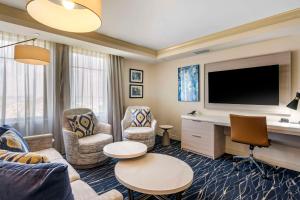 蓬塔戈尔达Wyvern Hotel, Ascend Hotel Collection的客厅配有电视、沙发和椅子