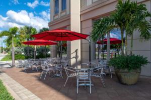 蓬塔戈尔达Wyvern Hotel, Ascend Hotel Collection的一组桌椅和红色遮阳伞