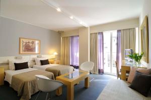 雅典Dorian Inn - Sure Hotel Collection by Best Western的酒店客房,设有两张床和一张沙发