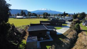 奥阿库尼5 Bedroom, Solar on Snowmass Ohakune, Yellow Door的一座小建筑,背景是一座山