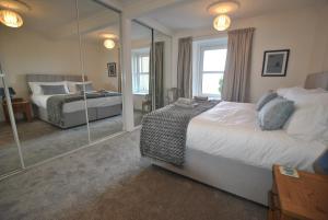 克雷尔Mariners Retreat- spacious apartment in Crail的一间卧室配有两张床和镜子