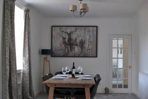 克雷尔Mariners Retreat- spacious apartment in Crail的用餐室配有带酒杯的木桌