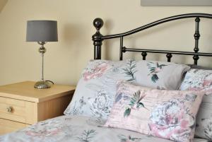KilrennyOrchard Cottage-spacious cottage in rural setting的床上配有枕头,床头柜上配有灯