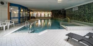 塔内安拉格谭恩帕克公寓酒店的大楼内带热水浴池的大型游泳池