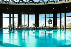 卡赞勒克Kings' Valley Medical & Spa Hotel的一座大型游泳池,位于一座带窗户的建筑内