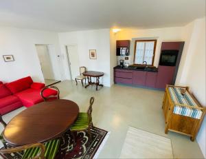 博尔扎诺Lauben Suite Old Town Bolzano的客厅配有红色的沙发和桌子