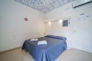阿祖罗港Affittacamere Vista Mare的一间设有一张蓝色图案天花板的床的客房