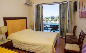 哈尔基斯来福卡迪酒店的一间卧室设有一张床,享有阳台的景色