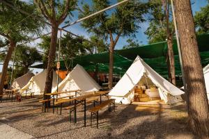 阿尔马亚特巴瑶Kampaoh Costa del Sol的一组帐篷,在田野里设有桌子和长凳