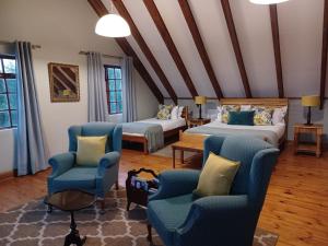 伯格维尔德拉肯斯堡山度假酒店的一间客房配有两张床、两把椅子和一张沙发