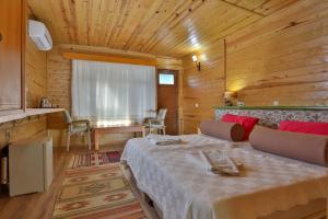 契拉勒Çıralı Orange Motel的木制客房内的一间卧室,配有一张床