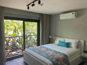 博德鲁姆Villa Oliva Butik Hotel的一间卧室配有一张床,阳台设有窗户