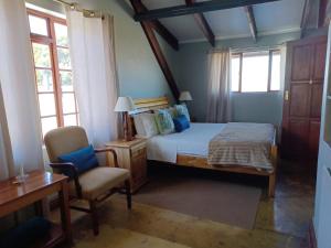 伯格维尔德拉肯斯堡山度假酒店的一间卧室配有一张床、一把椅子和窗户。
