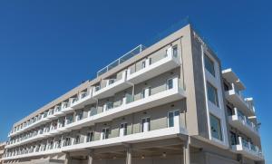 科斯镇Kos Divine Hotel & Suites的公寓大楼的背景是蓝色的天空